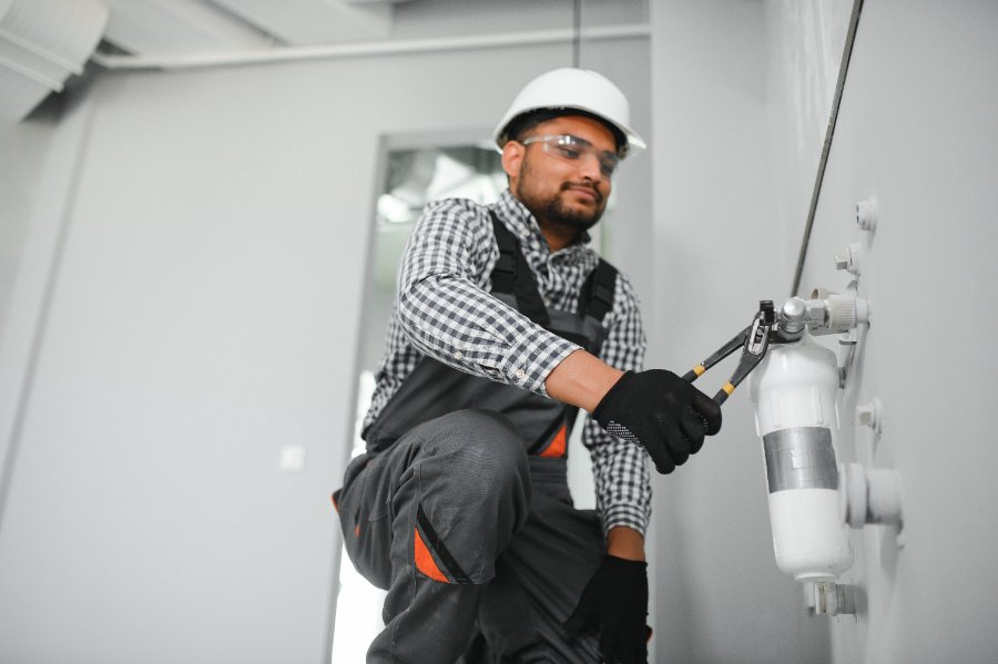 Technician servicing a whole-home water filtration cartridge housing